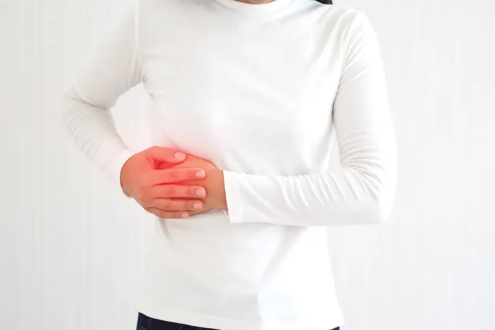 みぞおちを痛がる女性